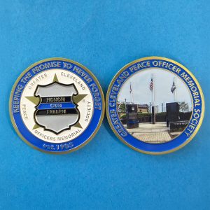 Front and back of the GCPOMS challenge coin featuring the Honor Our Fallen badge emblem and a photo of the Greater Cleveland Peace Officers Memorial site.
